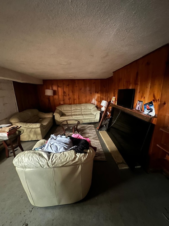 living room with wood walls and a textured ceiling