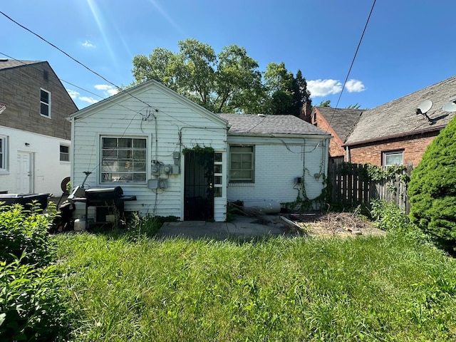 back of property featuring a lawn