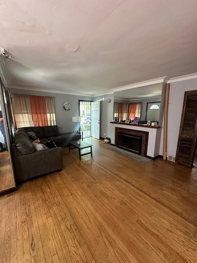 unfurnished living room with hardwood / wood-style floors and crown molding