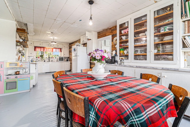 dining room featuring wood walls and sink