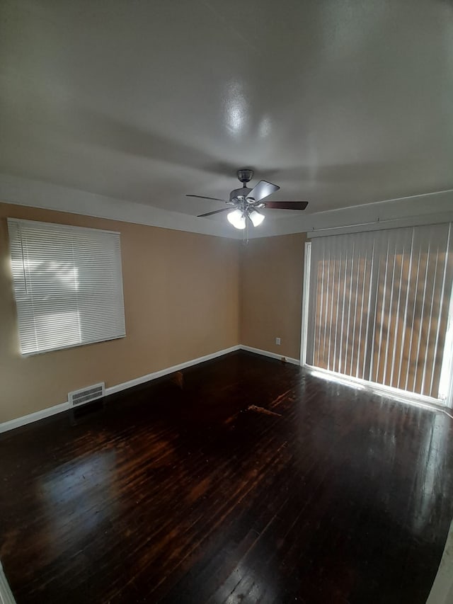 spare room with dark hardwood / wood-style floors and ceiling fan