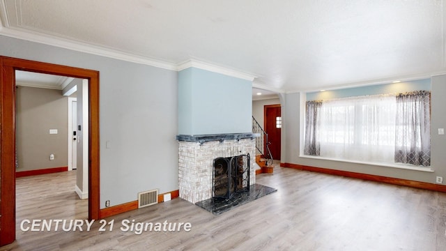 unfurnished living room featuring crown molding, a brick fireplace, and light hardwood / wood-style flooring