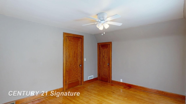 unfurnished room with ceiling fan, lofted ceiling, and light wood-type flooring