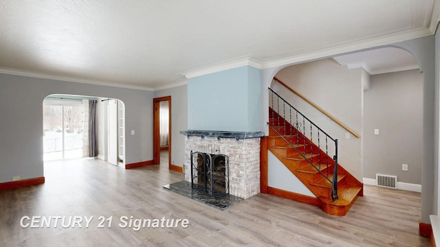 unfurnished living room with ornamental molding, wood-type flooring, and a brick fireplace