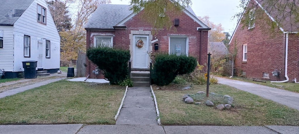 bungalow-style home with a front lawn