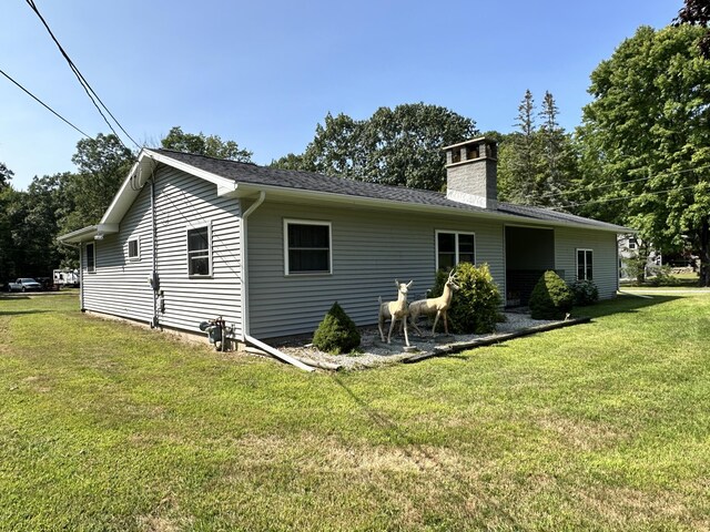 2717 N Sherman Rd, Ludington, MI 49431 - rear view of house featuring a yard and a chimney