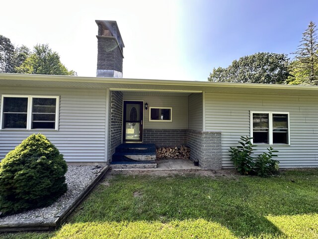 2717 N Sherman Rd, Ludington, MI 49431 - property entrance with a chimney and a lawn