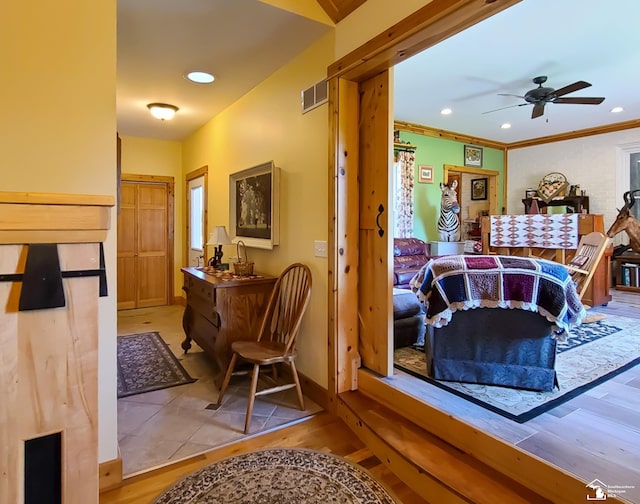 interior space featuring light wood-type flooring, ceiling fan, and ornamental molding