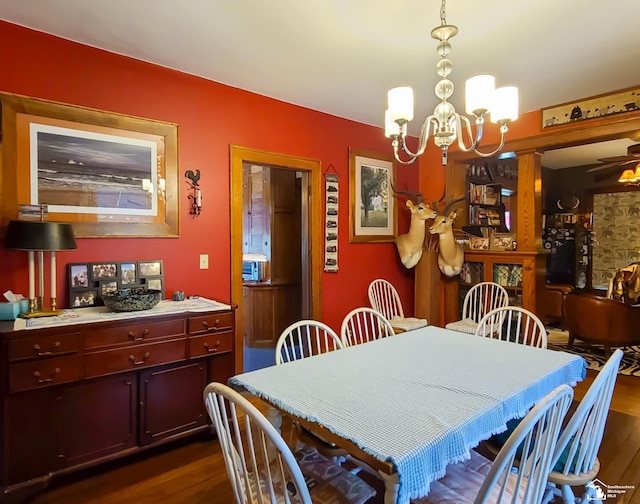 dining area with dark hardwood / wood-style floors and ceiling fan with notable chandelier