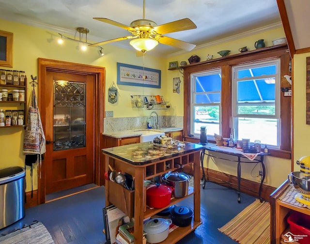 kitchen featuring crown molding, sink, ceiling fan, and light stone countertops