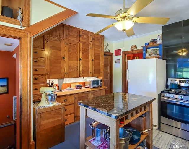 kitchen featuring crown molding, stainless steel gas stove, and ceiling fan