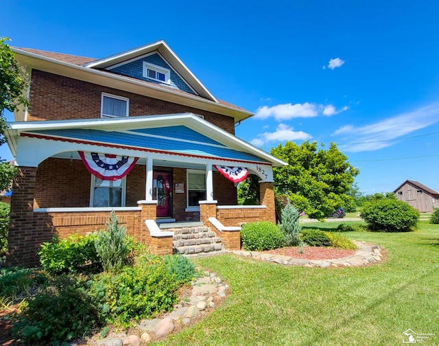 view of front of house with covered porch and a front yard