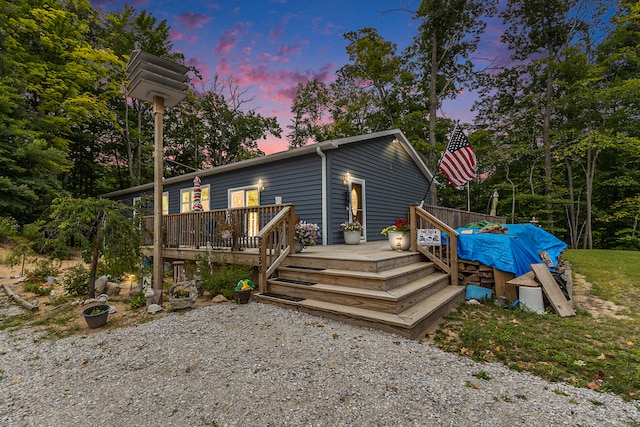 back house at dusk with a deck