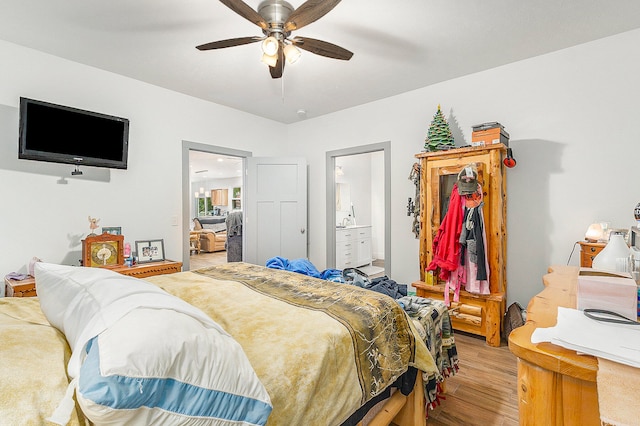 bedroom featuring light wood-type flooring, connected bathroom, and ceiling fan