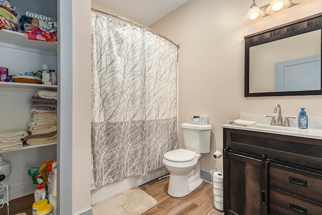 bathroom with hardwood / wood-style floors, vanity, and toilet