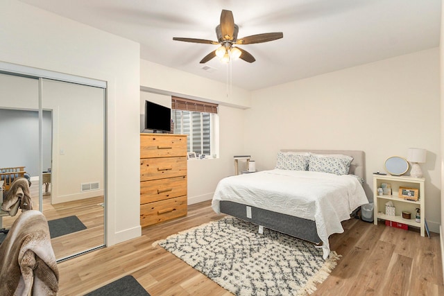 bedroom with a closet, light hardwood / wood-style floors, and ceiling fan