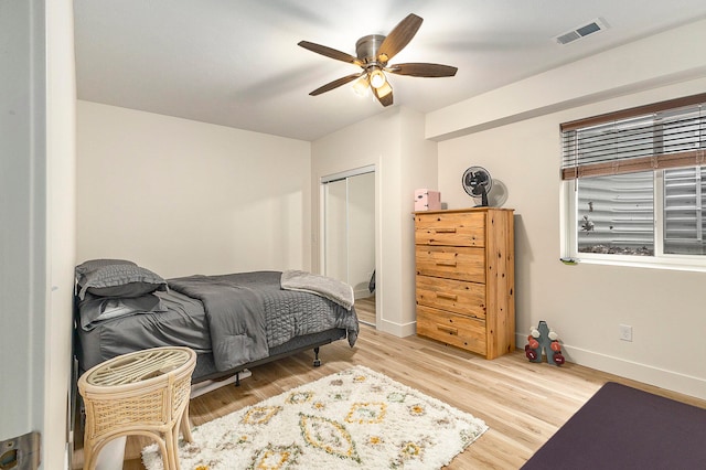 bedroom with ceiling fan, a closet, and light hardwood / wood-style flooring