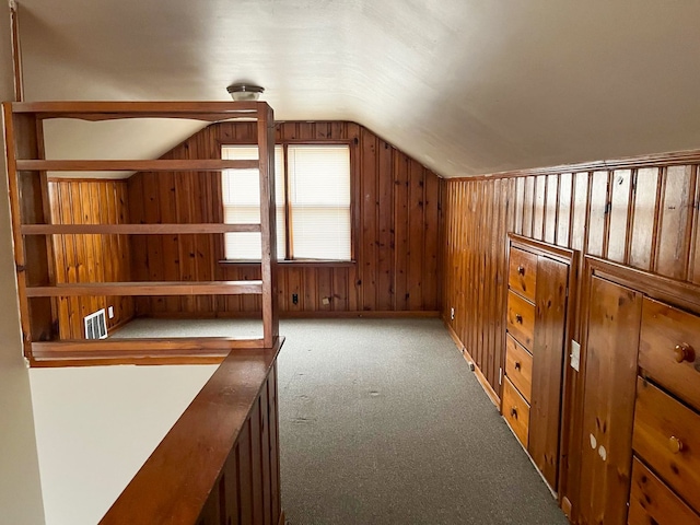 additional living space featuring wood walls, carpet, and vaulted ceiling