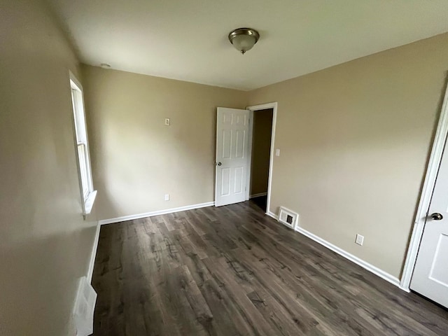 unfurnished bedroom featuring dark hardwood / wood-style flooring