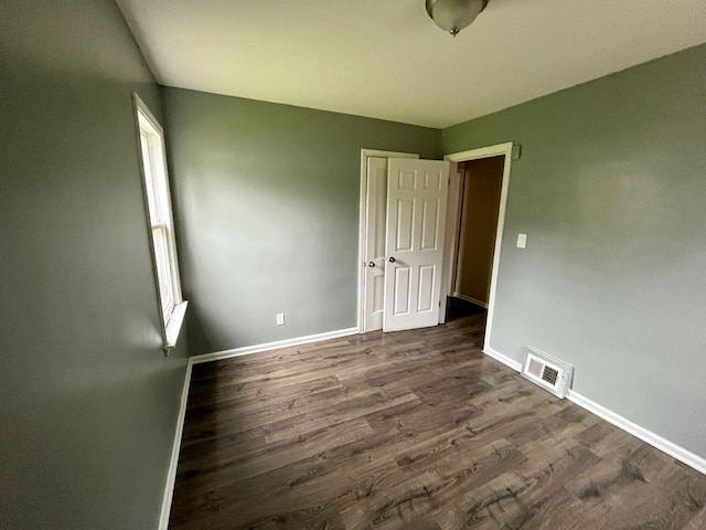 unfurnished room featuring dark wood-type flooring