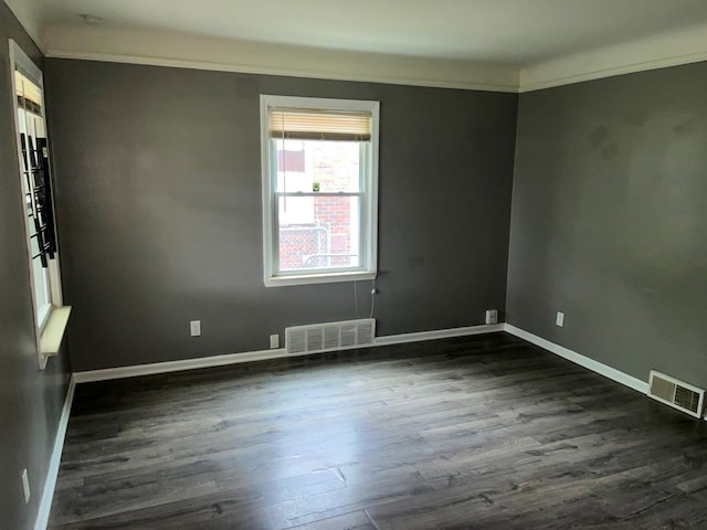 empty room featuring dark hardwood / wood-style floors and ornamental molding