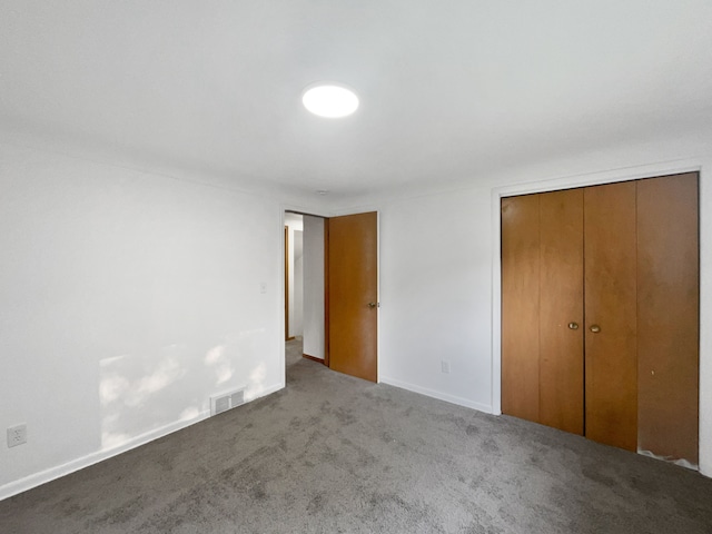 unfurnished bedroom with light colored carpet and a closet