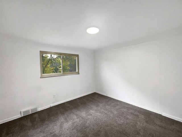 empty room featuring dark colored carpet