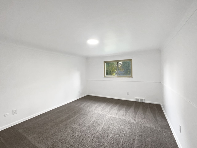 unfurnished room with dark carpet