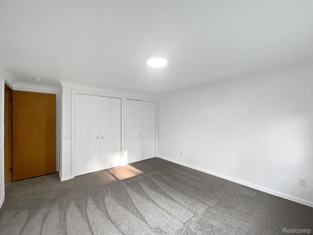 53044 Ruann Dr, Shelby Twp, MI 48316 - unfurnished bedroom featuring two closets and dark carpet