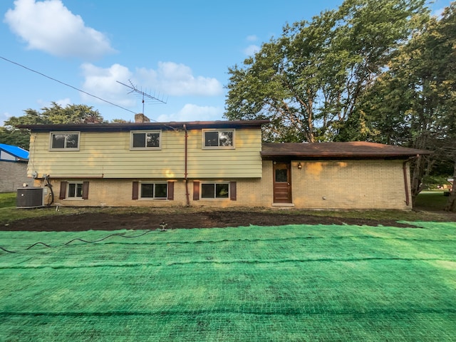 back of house with a lawn and central AC unit