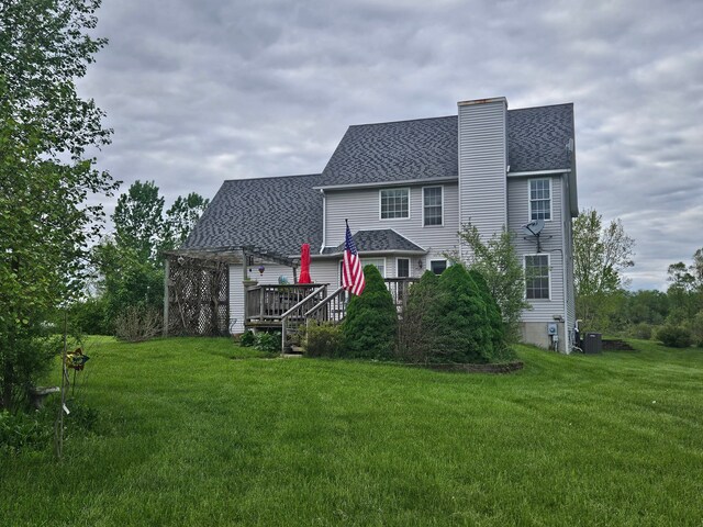 rear view of house with a lawn, central air condition unit, and a deck