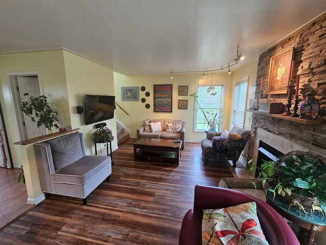 living room with dark hardwood / wood-style flooring, rail lighting, and ornamental molding