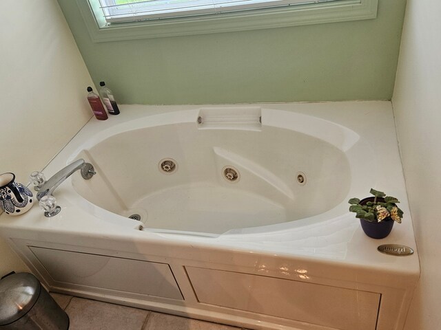 bathroom with a tub to relax in and tile patterned floors