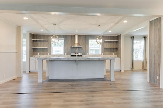 714 Mill St Unit 27, Leslie, MI 49251 - kitchen featuring open shelves, a chandelier, wall chimney exhaust hood, a center island with sink, and beamed ceiling