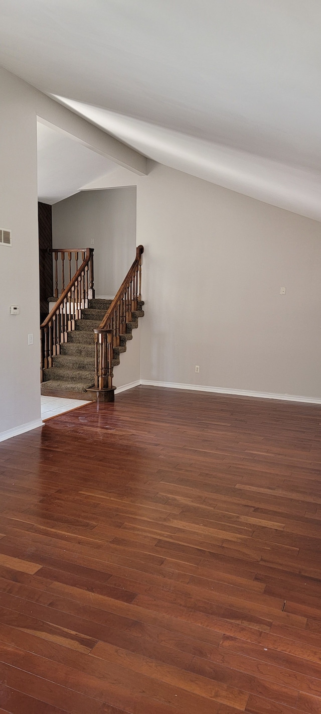 unfurnished room with dark hardwood / wood-style floors and lofted ceiling