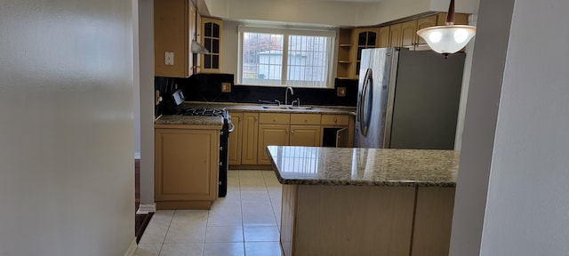 kitchen with light brown cabinetry, light tile patterned floors, sink, and stainless steel refrigerator