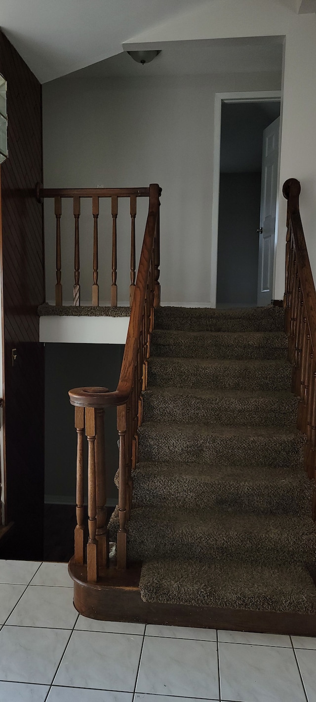 stairs with tile patterned floors and lofted ceiling