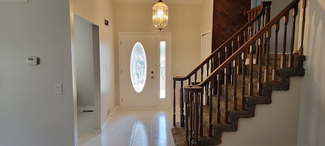 tiled foyer entrance featuring a chandelier