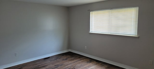 unfurnished room with dark wood-type flooring