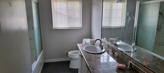 full bathroom featuring shower / bath combination with glass door, vanity, toilet, and a wealth of natural light