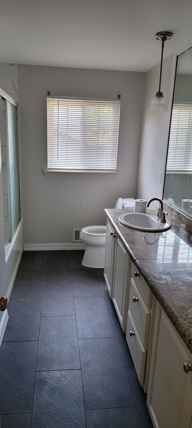 full bathroom with tile patterned flooring, vanity, toilet, and a wealth of natural light