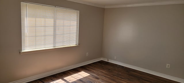 spare room featuring dark hardwood / wood-style floors and crown molding