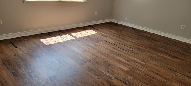 unfurnished room with dark hardwood / wood-style flooring