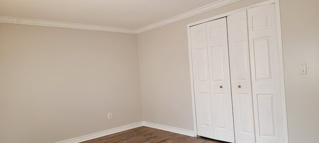 unfurnished bedroom featuring a closet, crown molding, and dark hardwood / wood-style flooring