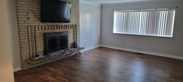 unfurnished living room featuring dark hardwood / wood-style floors, a brick fireplace, and crown molding