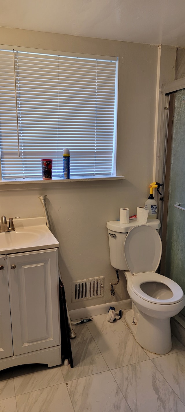 bathroom featuring vanity, an enclosed shower, and toilet