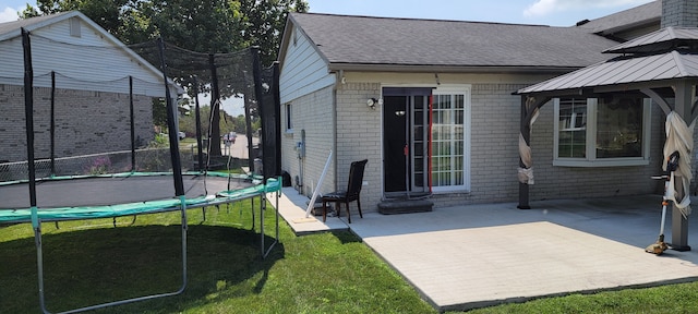 exterior space featuring a trampoline and a patio