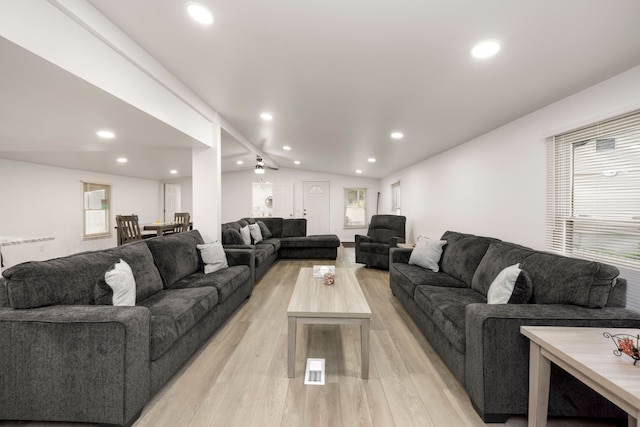 living room featuring vaulted ceiling with beams, ceiling fan, plenty of natural light, and light wood-type flooring