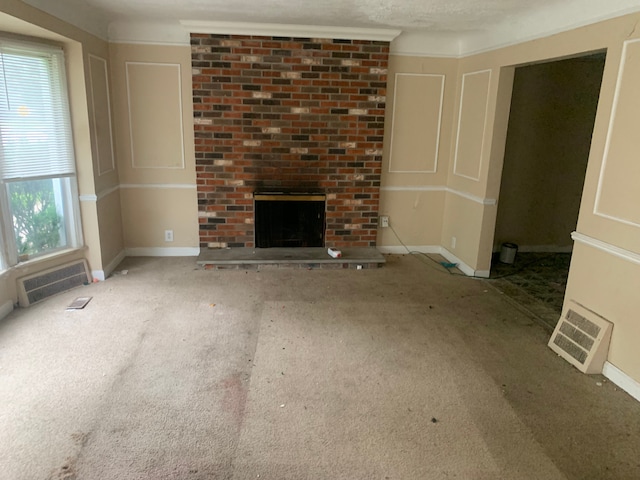 unfurnished living room featuring carpet, a fireplace, and a textured ceiling