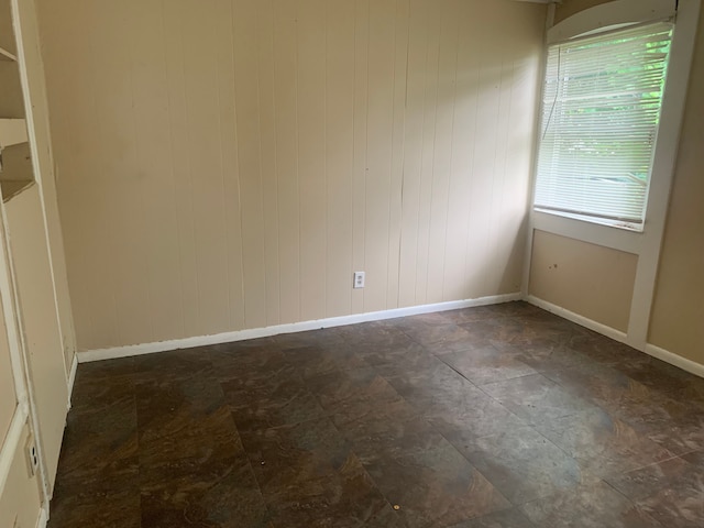 unfurnished room with wooden walls